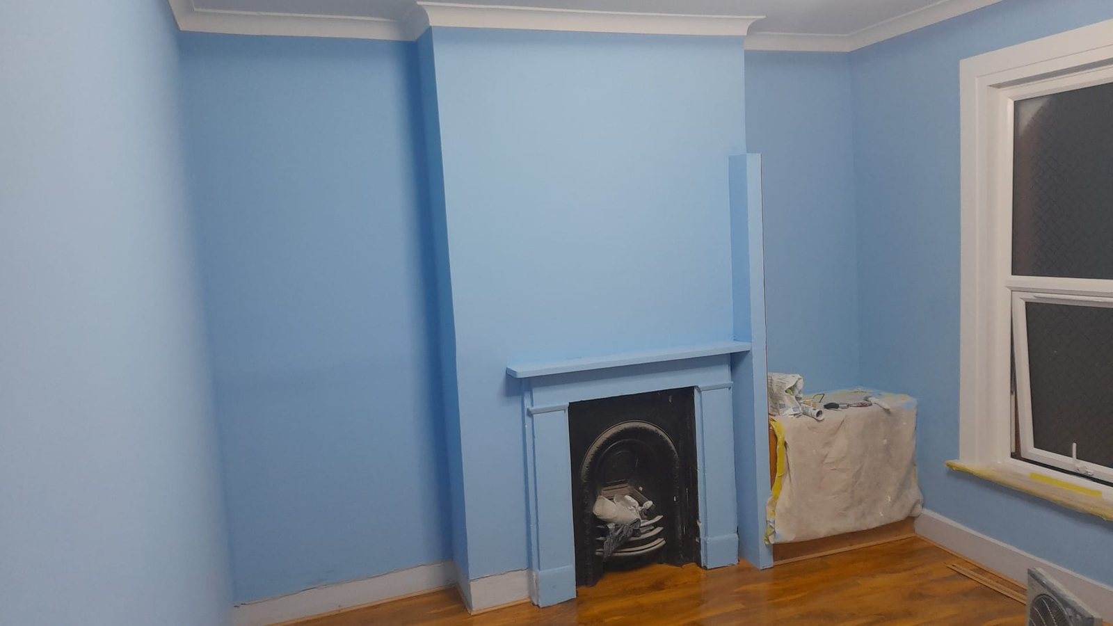 Front room in East London repainted with new wood flooring by A&C Property Maintenance